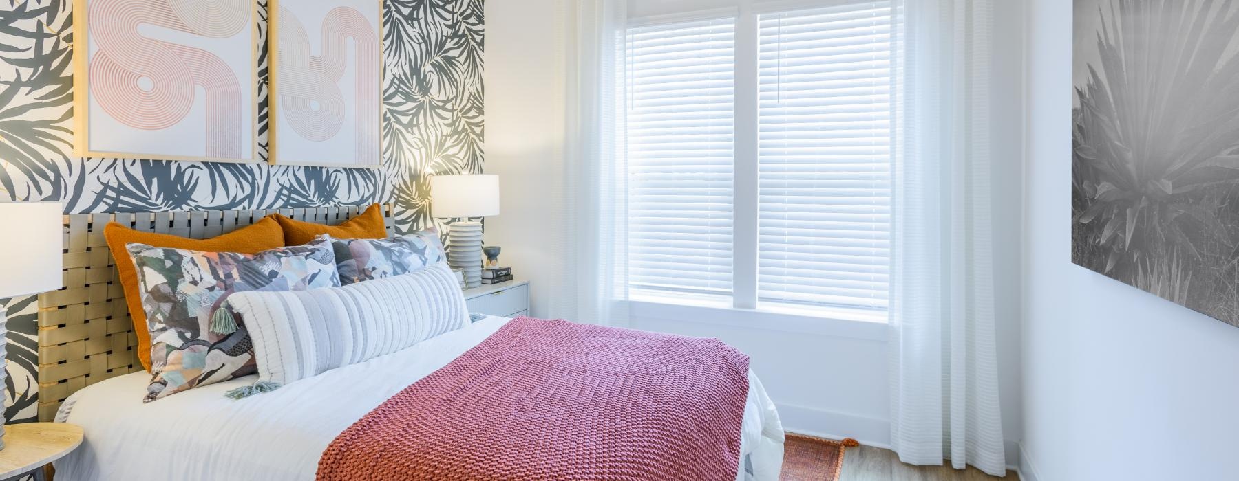 a bedroom with a bed and a pink blanket