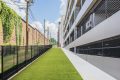 New Apartments in Charlotte, NC - The Artizia at Loso - Dog Park with Astroturf Alongside Apartment Complex in a Gated Area