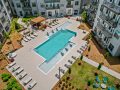 Pet-Friendly Apartments in Charlotte, NC - The Artizia at Loso - Aerial View of Saline Resort-Style Pool, Lounge Chairs, and Additional Seating Covered by a Cabana